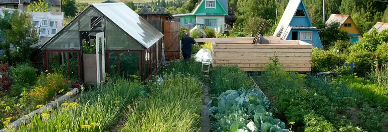 Outdoor greenhouse and garden beds with co-located infrastructure for waste heat reuse and stormwater management